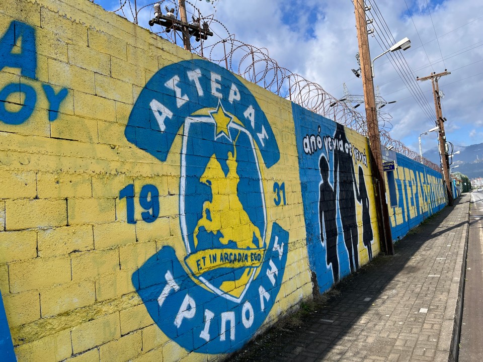 Mural on a brick wall depicting a team logo and family figures.
