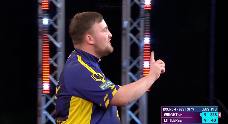 Darts player gesturing during a match.