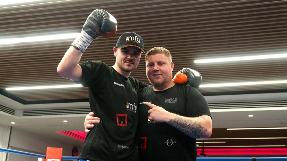Two boxers, one with his arm raised in victory.