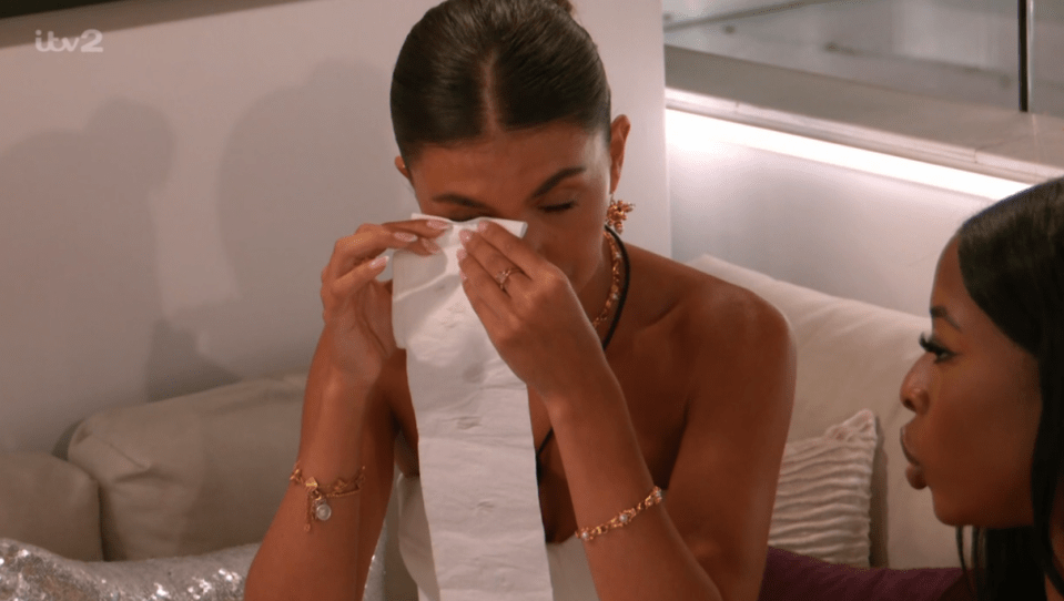 Screenshot of a woman crying while another woman looks on.