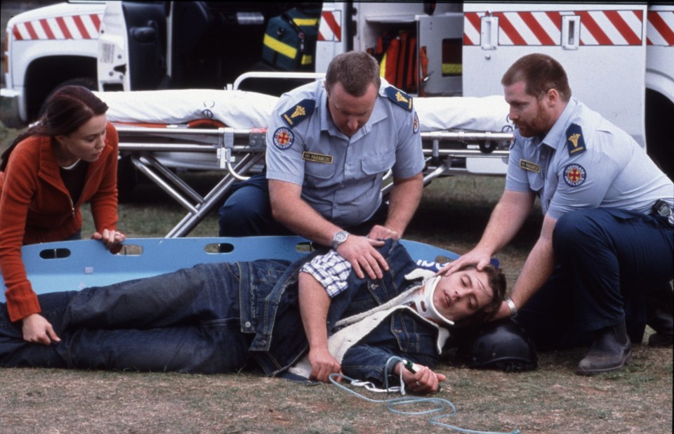 Scene from Neighbours showing paramedics attending to an injured man.