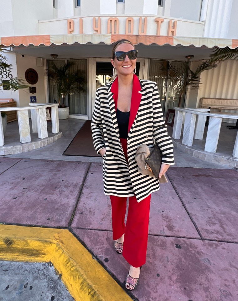 Woman in a striped blazer and red pants standing in front of the Plymouth Hotel.