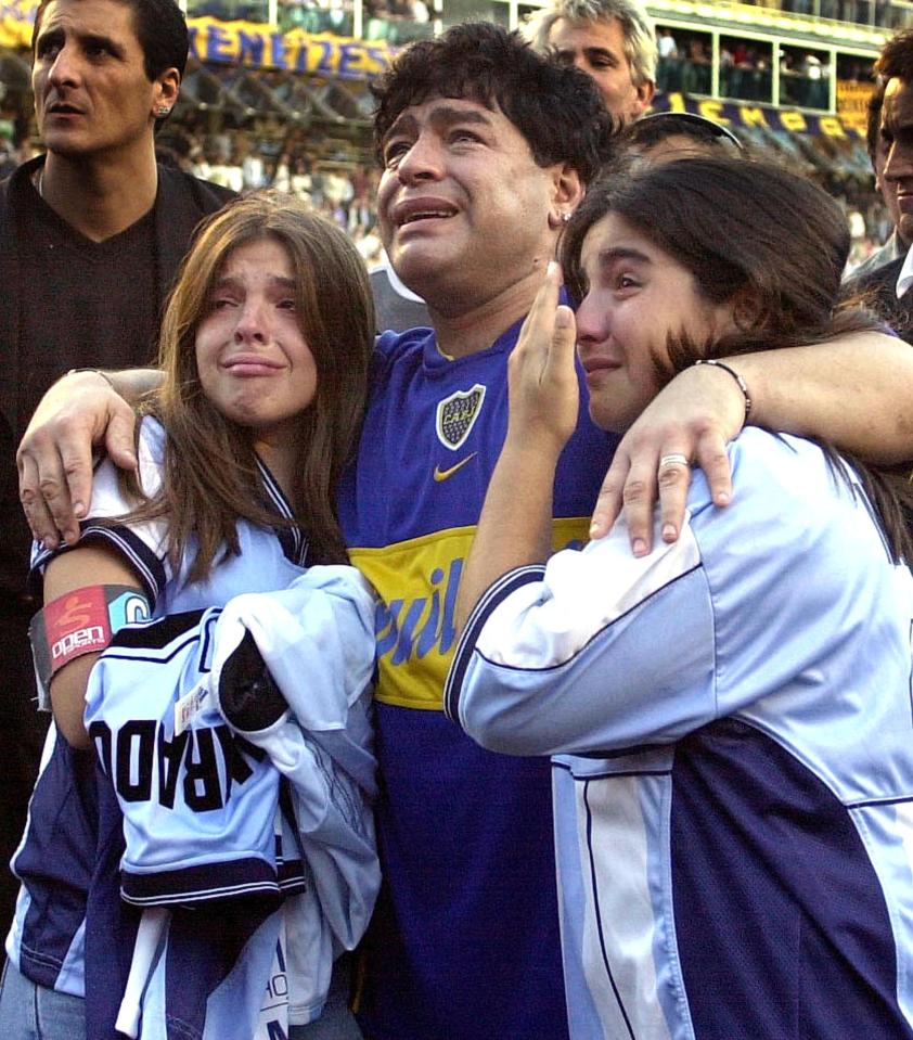 Diego Maradona crying with his daughters at a stadium.