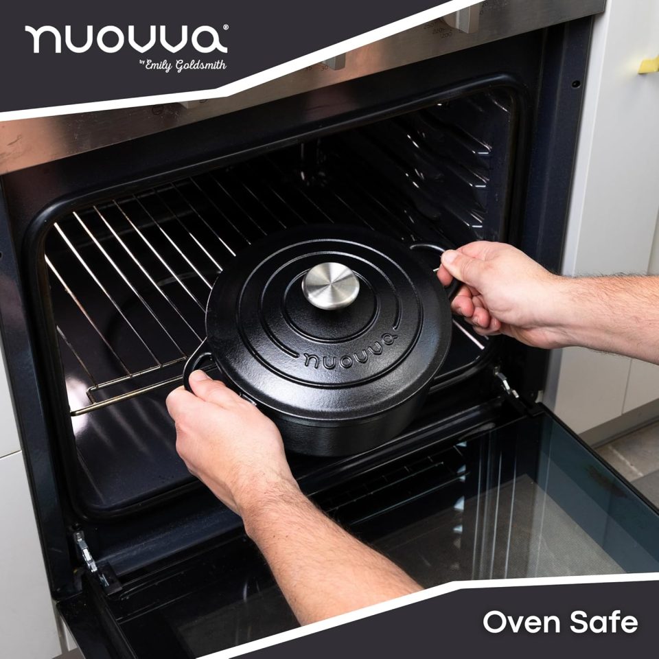 Hands placing a black cast iron pot into an oven.
