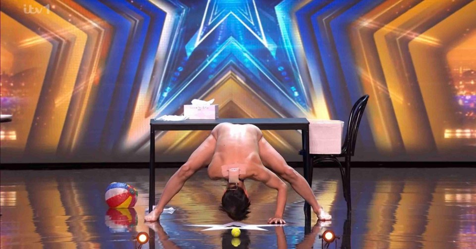 A performer bending over a table on Britain's Got Talent.