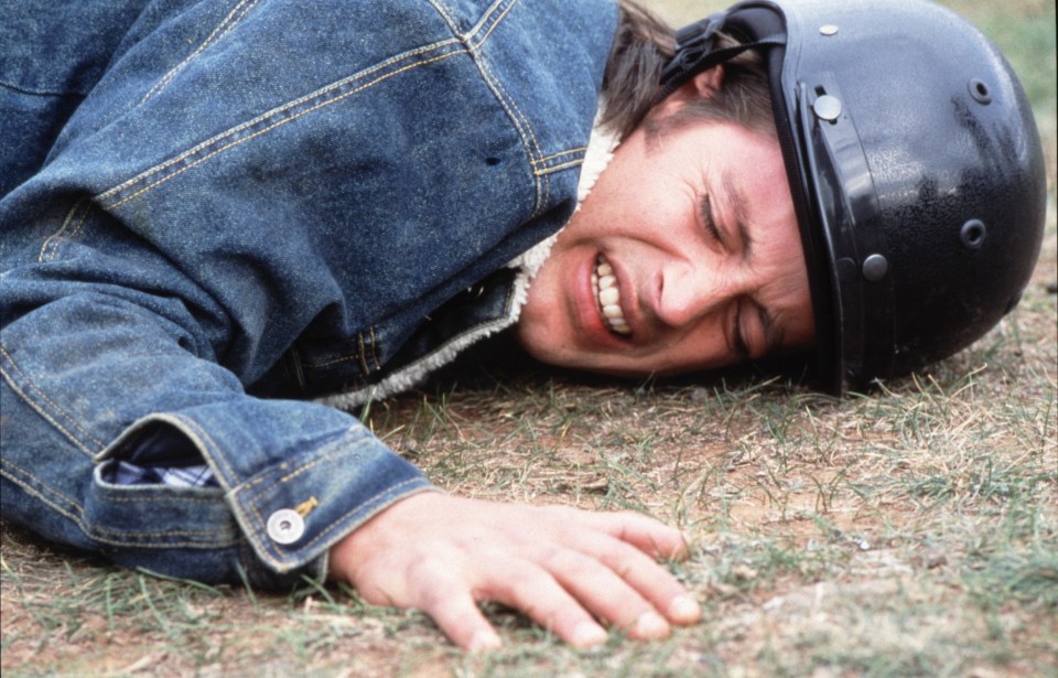 Dan Paris, Neighbours TV actor, lying on the ground injured.