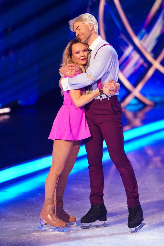 Charlie Brooks and Eric Radford embracing on the ice after an ice skating performance.