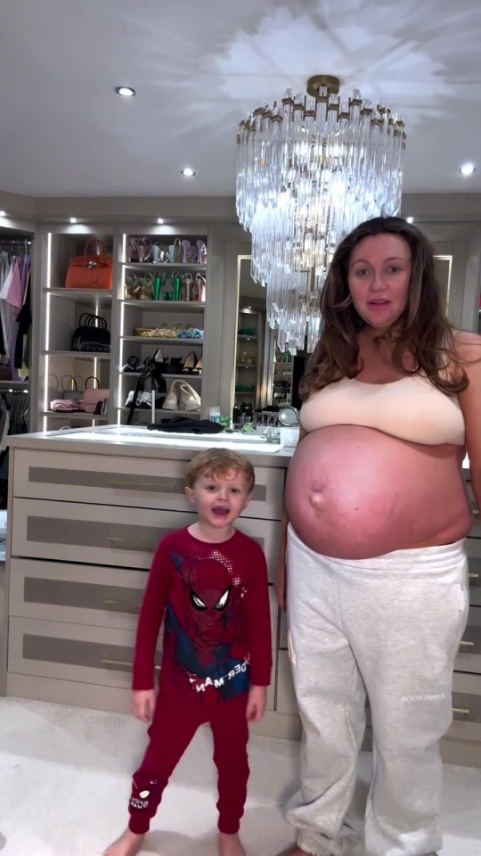 A pregnant woman and her young son stand in front of a walk-in closet.