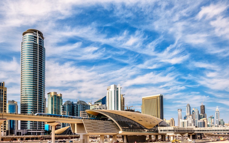 Dubai Jumeirah Lakes Towers metro station with skyscrapers in the background.