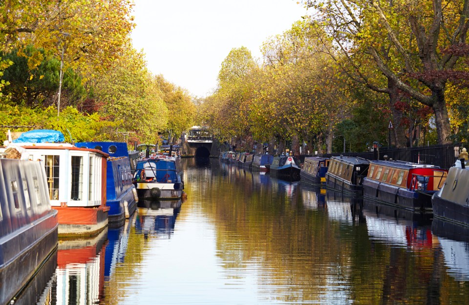 Canal boats moored along a canal in Little Venice, London.