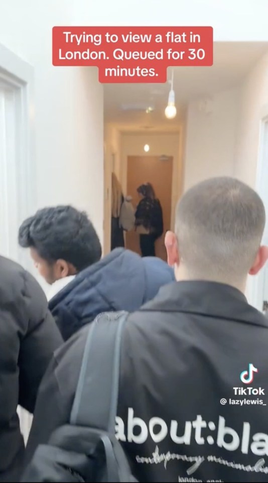 Long queue of people waiting to view a London flat.