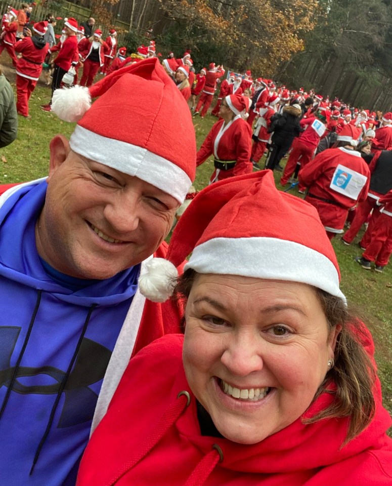 Couple in Santa hats at a Christmas event.