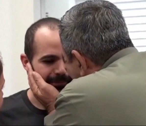 A man embracing another man after his release from captivity.