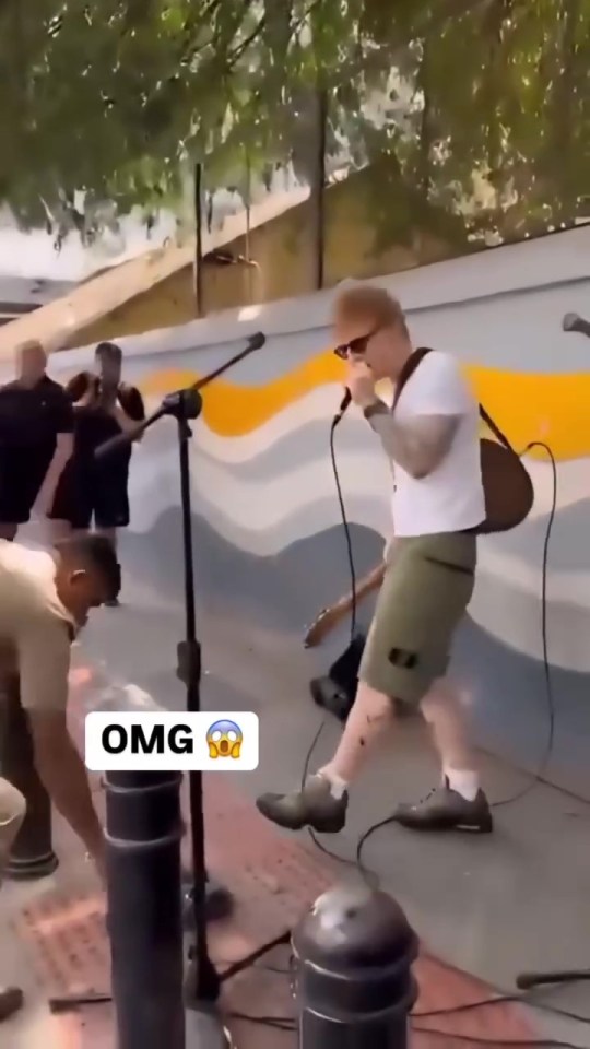 Ed Sheeran performing on a street, stopped by police.