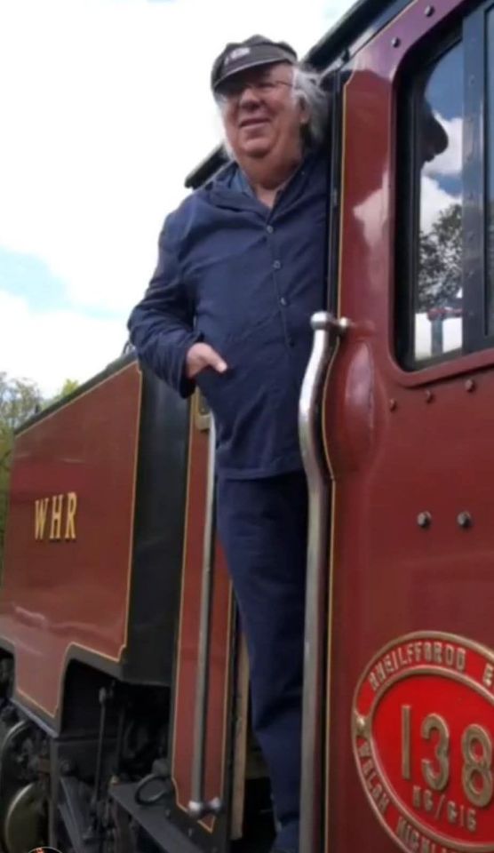 Chris Hughes, Eggheads quizzer, standing by a train.