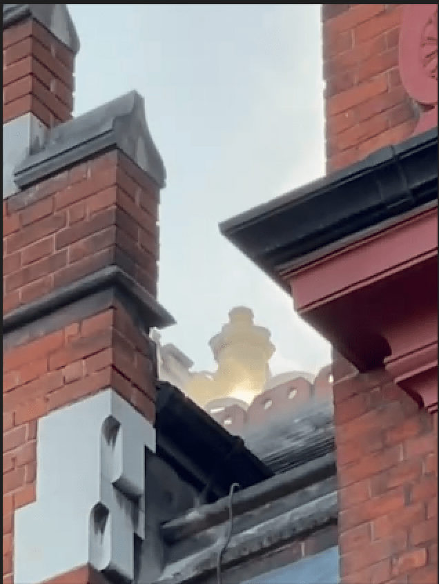 Fire damage to the roof of a brick building.