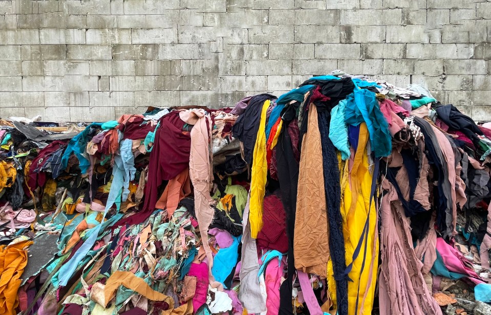 Pile of discarded clothing in a landfill.