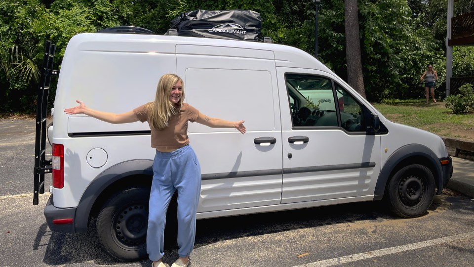 Gabby Petito standing next to a white van.