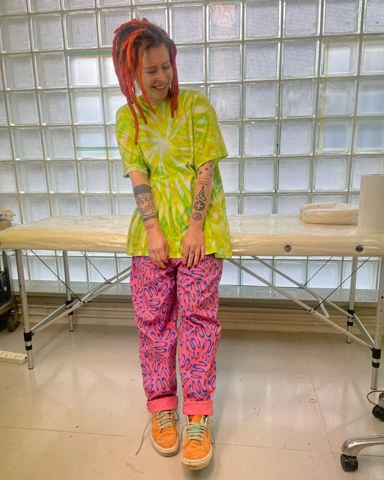 Holly Rivers wearing pink pants and a tie-dye shirt.