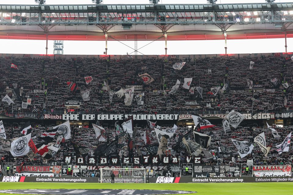 Soccer fans displaying flags and scarves in a stadium.