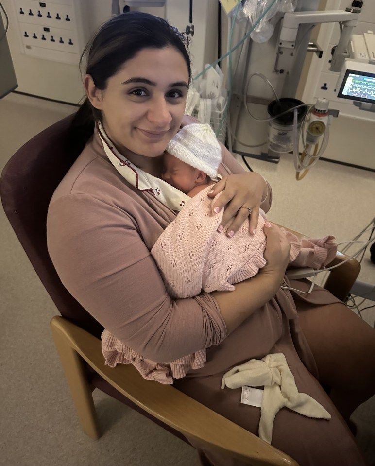 A mother holding her newborn baby in a hospital.