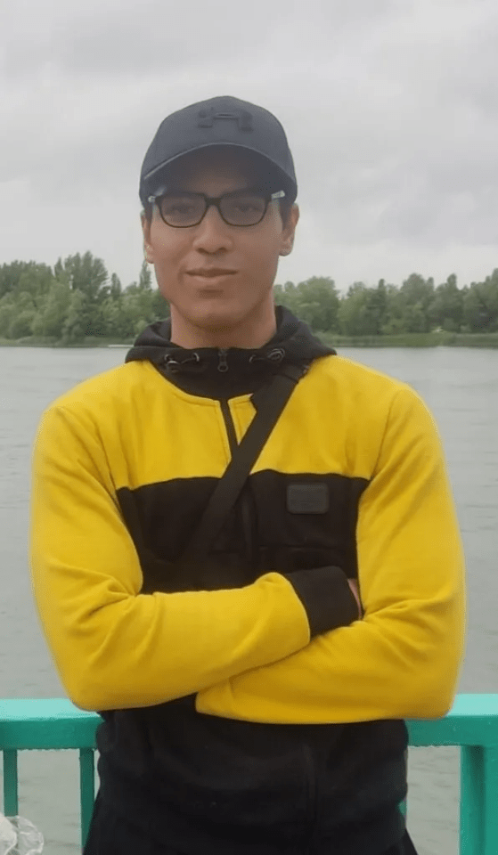 Man in yellow and black sweatshirt with arms crossed.