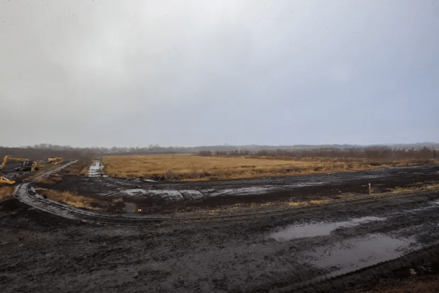 Construction site with muddy ground and heavy machinery.