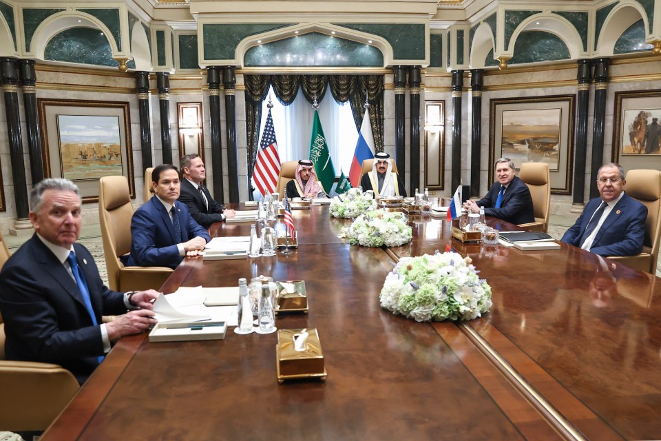 Group of men sitting around a large conference table.