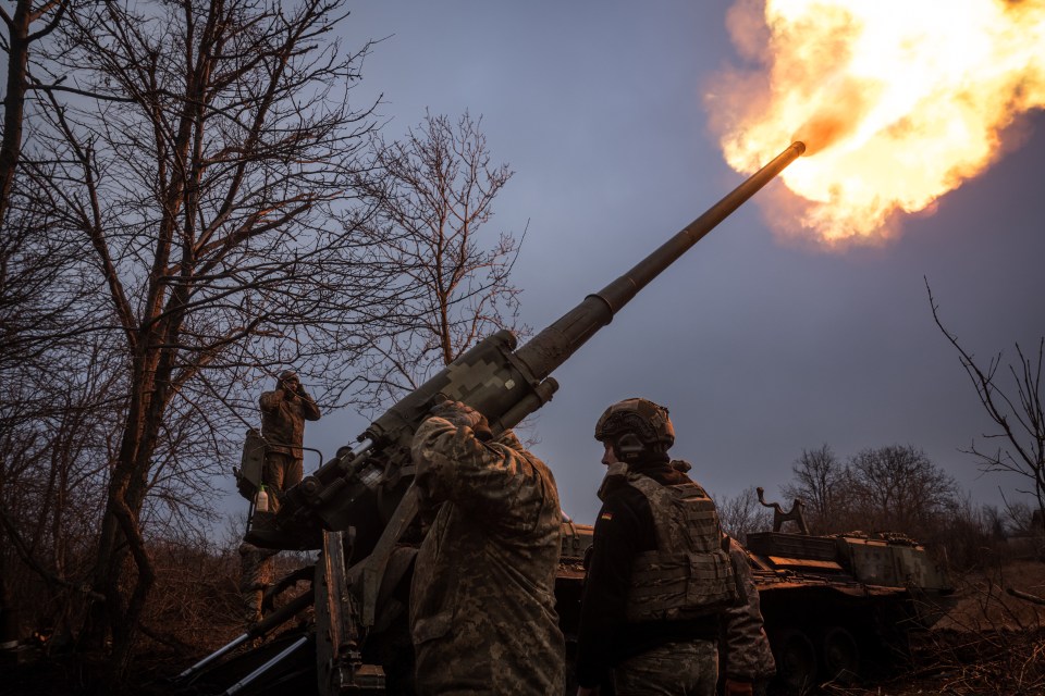 Soldiers firing a howitzer.