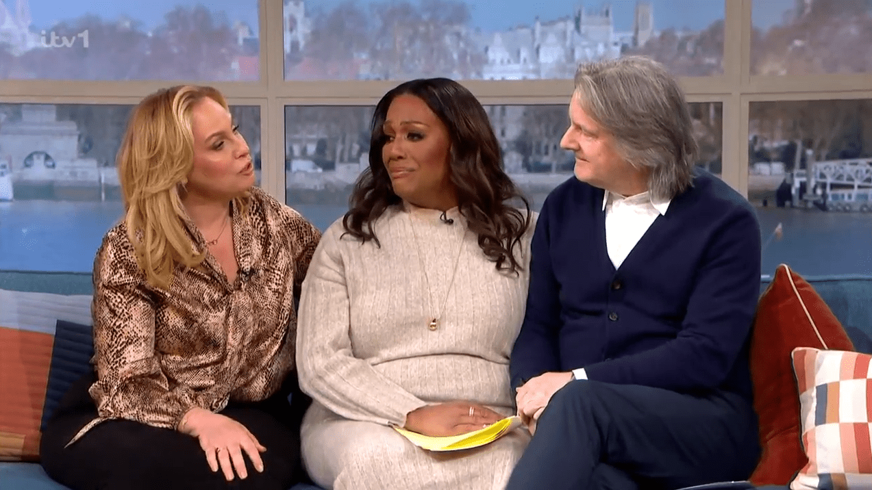 Three people sitting on a couch during a television interview.