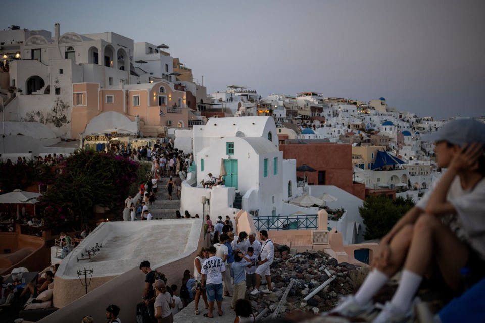 Crowded Santorini streets at dusk.