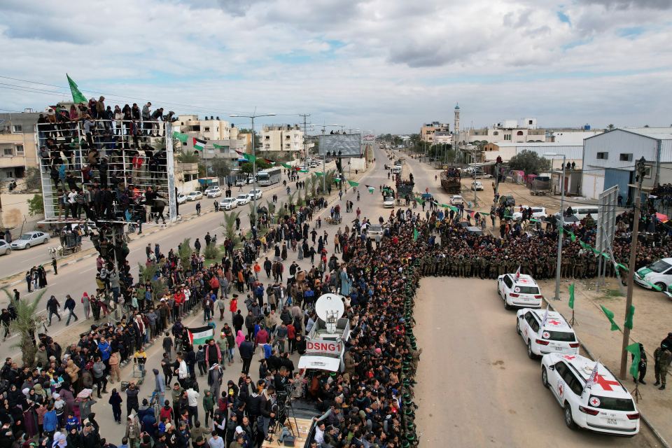 International Red Cross vehicles wait amid a large crowd of people in Gaza.