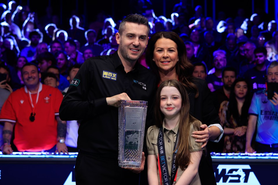 Mark Selby and his family posing with a trophy.