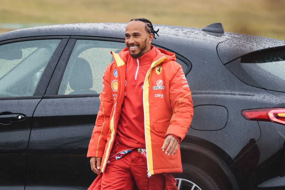 Lewis Hamilton in Ferrari gear greeting fans.
