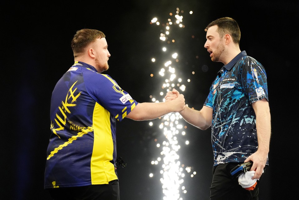 Two darts players shaking hands after a match.