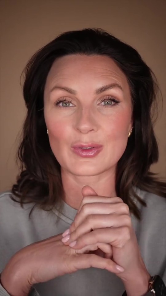 Woman demonstrating a makeup trick.