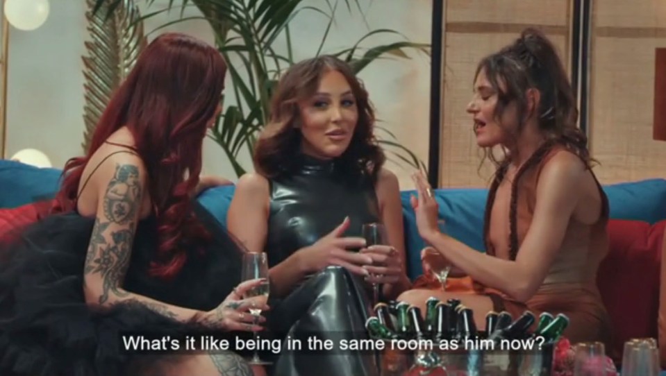 Three women sitting on a couch, talking.