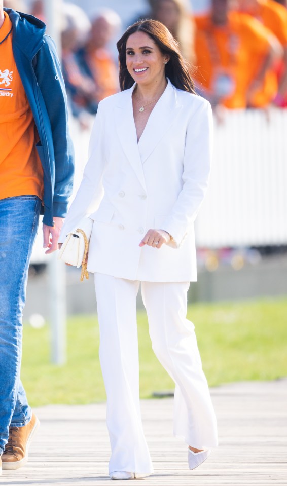Meghan, Duchess of Sussex, at an Invictus Games reception in a white pantsuit.