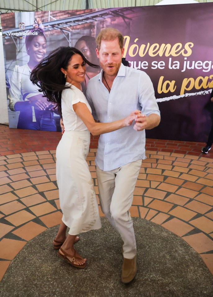 Meghan Markle and Prince Harry dancing together.
