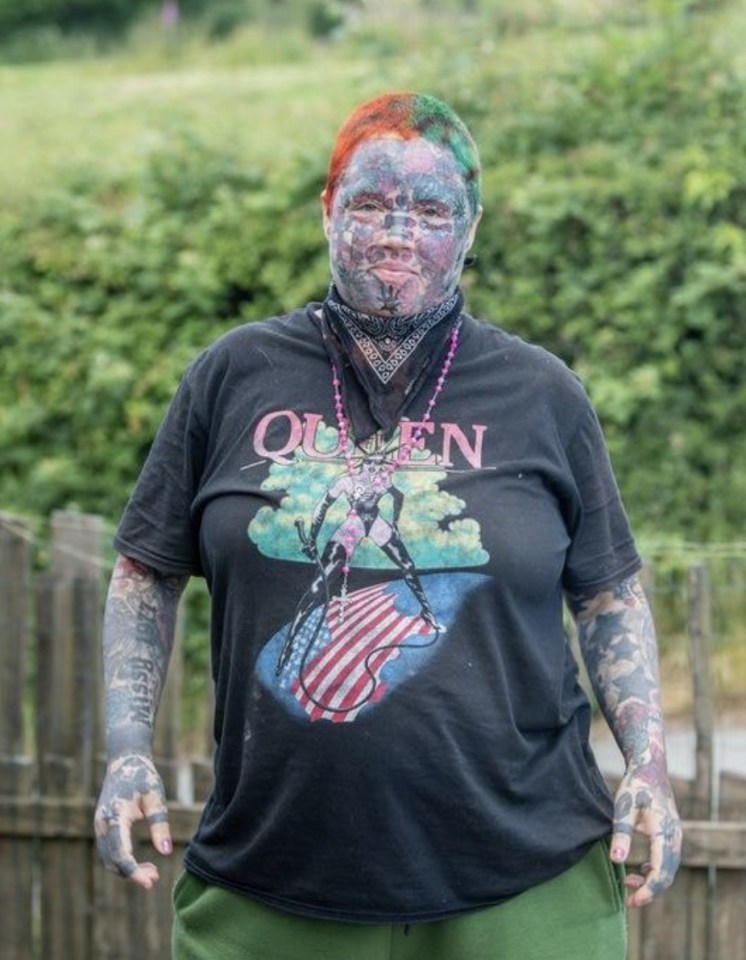 Portrait of Melissa Sloan, a heavily tattooed woman, wearing a Queen t-shirt.