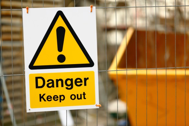Warning sign on a building site fence