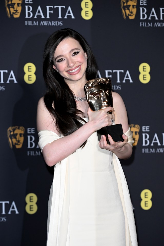 Mikey Madison holding a BAFTA award.