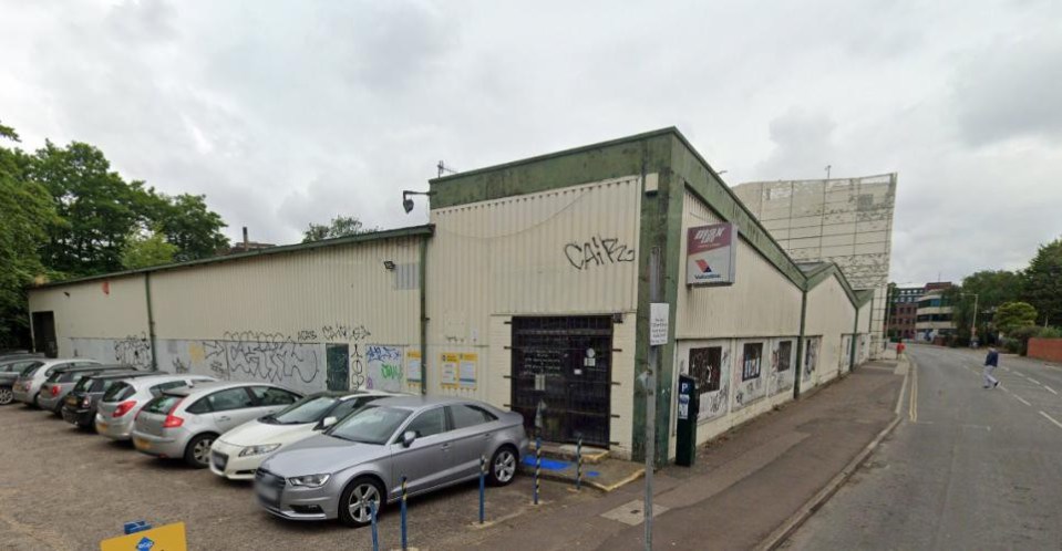 Building with graffiti and parked cars.