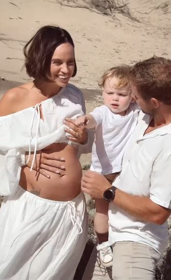 Pregnant woman with her family on a beach.