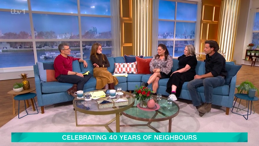 Four actors from the TV show Neighbours sitting on a sofa during a television interview.