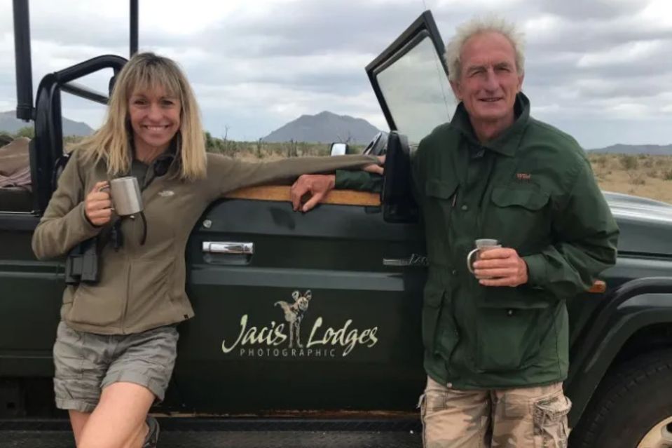 Michaela Strachan and Nick Chevallier with mugs, leaning on a Jais Lodges Photographic vehicle.