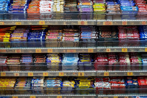 An image collage containing 1 images, Image 1 shows Assortment of chocolate bars on store shelves