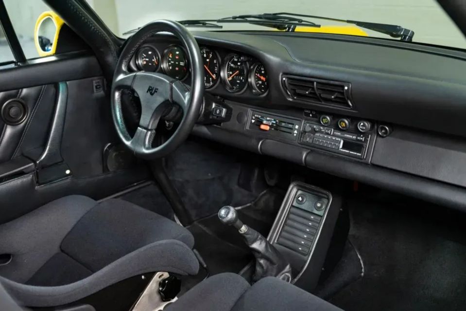 Interior of a black and yellow Porsche.