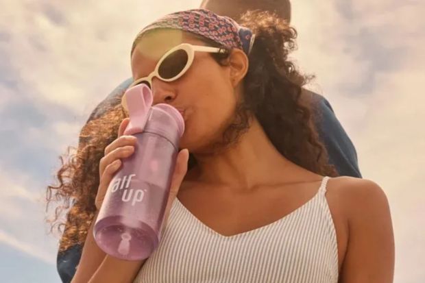 An image collage containing 1 images, Image 1 shows Woman drinking from a purple Air Up water bottle