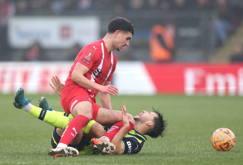 Nico Gonzalez of Manchester City challenged by Sonny Perkins of Leyton Orient during a soccer match.